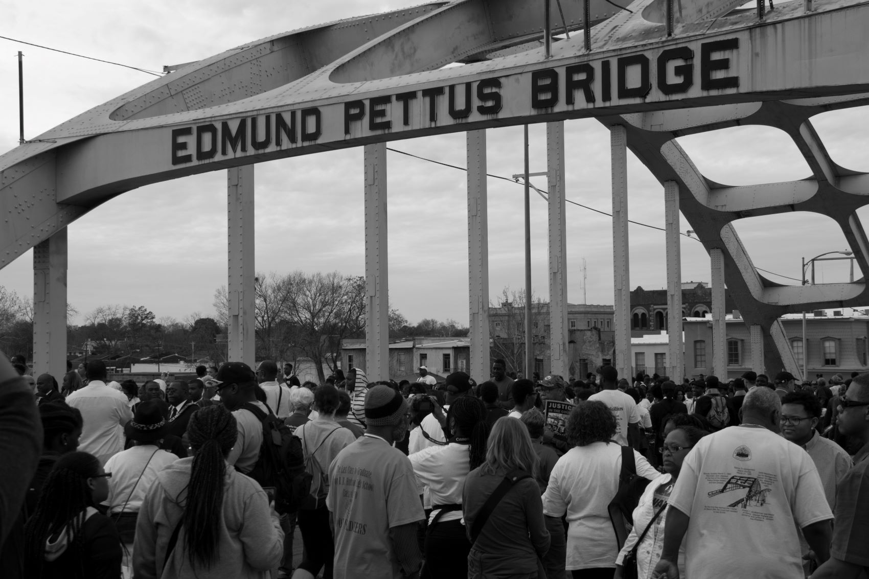 A black and white photo from the 1960s of Martin Luther King Jr leading a large crowd of activists in a march