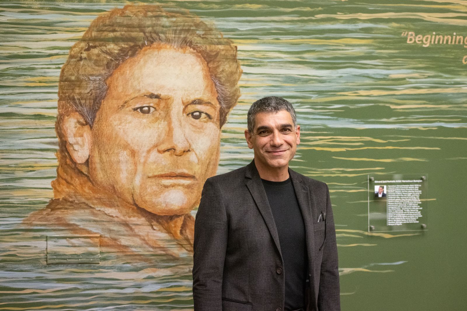 Haroutioun Bastajian standing next to his artwork